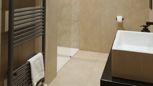 Ein modernes Badezimmer mit einer Badewanne, einem Handtuchhalter und einem Toilettenpapierhalter.
