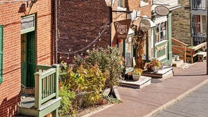A street view with a brick building, a green awning, and a sign for 'The Rabbit Hole.' - Historic High Street Retreat (Harpers Ferry)