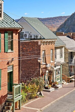 Vista de calle con un edificio de ladrillo, un toldo verde y un letrero que dice 'The Rabbit Hole'.