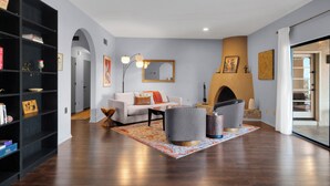 Una sala de estar moderna con chimenea, un sofá, sillones y una estantería.