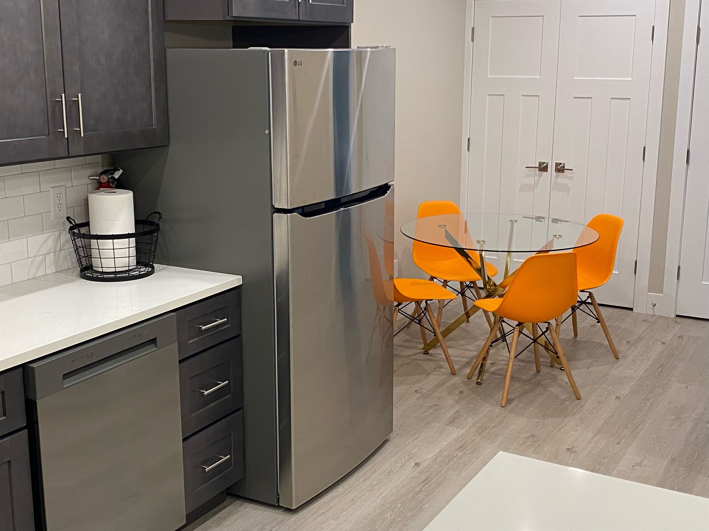 Dining nook with a glass table and orange chairs