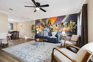Ein Wohnzimmer mit blauem Sofa, Holztisch und gemustertem Teppich.