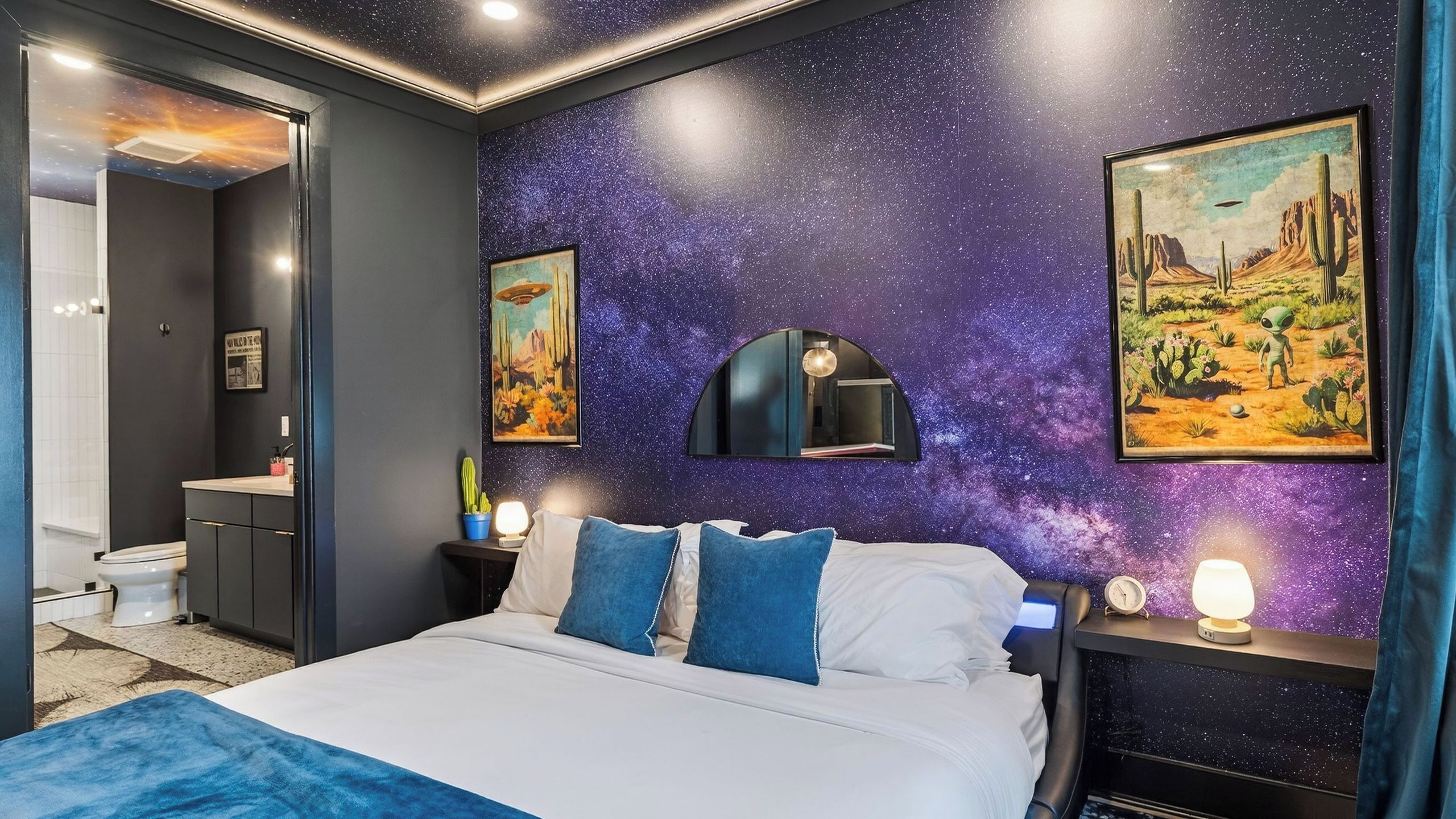 A bedroom with a bed, nightstands, a mirror, and a wall with a starry pattern.