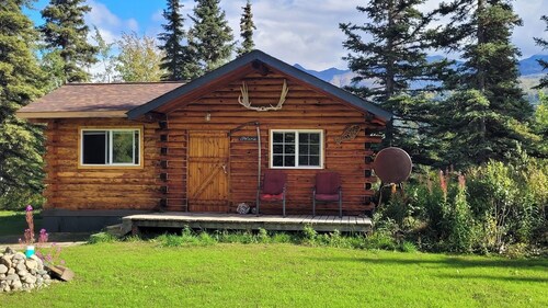Nestled in a bed of wild flora, enjoy the spectacular views from your authentic log cabin.