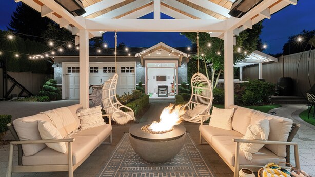 A covered outdoor seating area with a fire pit, white sofas, and wicker chairs. - SOWDEN HOUSE - Amazing & unique home located less than 20 minutes to down town. (North Vancouver)