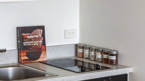 Eine moderne Küche mit einer Edelstahl-Dunstabzugshaube, einem Kombi-Backofen und einer Arbeitsplatte mit Gewürzgläsern.