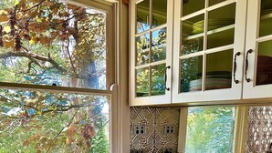Una cocina con ventana, armarios y un tostador.