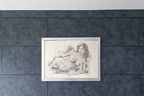 Eine gerahmte Schwarz-Weiß-Zeichnung an einer strukturierten grauen Wand.