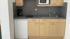 A compact kitchen with a microwave, coffee maker, and dishwasher. - Studio Héliopolis C 36 - 4 people (AGDE)