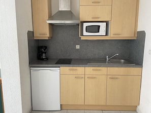 A compact kitchen with a microwave, coffee maker, and dishwasher. - Studio Héliopolis C 36 - 4 people (AGDE)