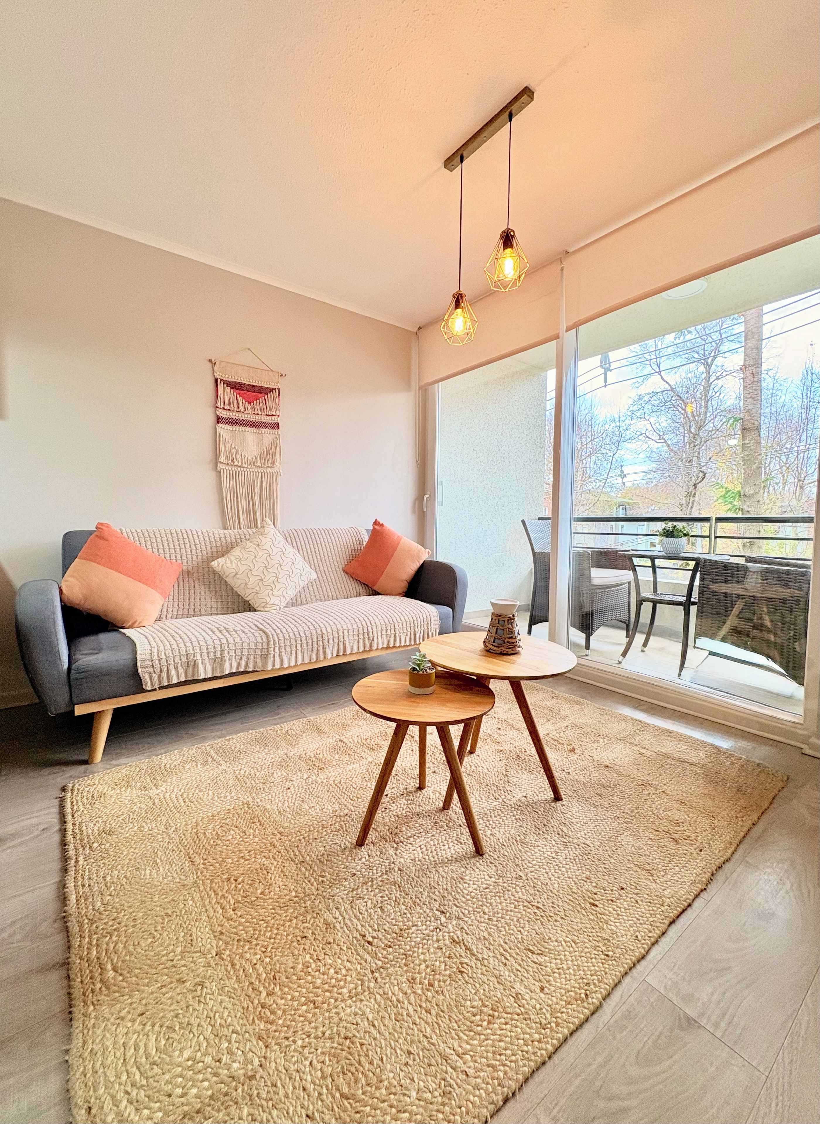 A modern living room with a sofa, a small round table, and a large window.