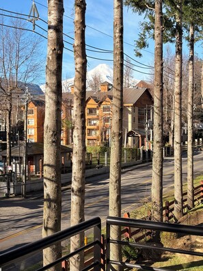 Un quartier résidentiel caractérisé par de grands arbres, une route dégagée et des immeubles dotés de balcons.