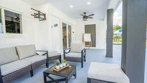 A spacious patio area with wicker furniture, a ceiling fan, and a view of the outside. - Spacious 7-bedroom house in delightful Southwest Ranches with AC (Southwest Ranches)