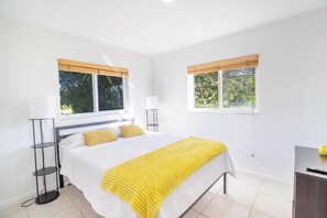 A bedroom with a bed, two bedside tables, and two windows with blinds. - Spacious 7-bedroom house in delightful Southwest Ranches with AC (Southwest Ranches)