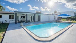 A swimming pool with a clear blue water, surrounded by a concrete deck. - Spacious 7-bedroom house in delightful Southwest Ranches with AC (Southwest Ranches)