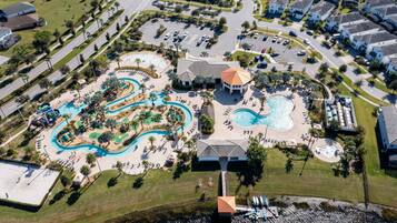 Vue aérienne d’un complexe hôtelier doté de plusieurs piscines, d’un parc aquatique et d’un club-house.