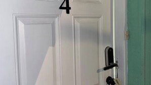 A white door with the number 4, a keyhole, and a keyring with a key and a tag. - Cozy 1-bedroom studio in perfect Tampa with AC (Tampa)