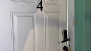 A white door with the number 4, a keyhole, and a keyring with a key. - Cozy 1-bedroom studio in perfect Tampa with AC (Tampa)