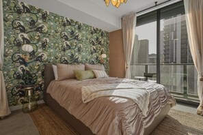 A bedroom with a large bed, a city view through a sliding door, and a patterned wallpaper. - New Luxury Studio Downtown Miami Prime Location (Miami)