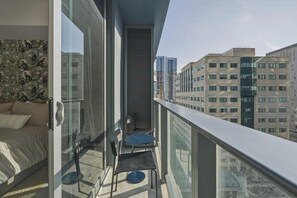 A balcony with a bed, a chair, and a small table. - New Luxury Studio Downtown Miami Prime Location (Miami)