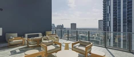 A rooftop lounge with outdoor seating and a city view.
