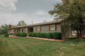 A single-story mobile home with a porch, a small front yard, and a tree. - Heart of the Hocking Hills Lodge Newly renovated (Rockbridge)