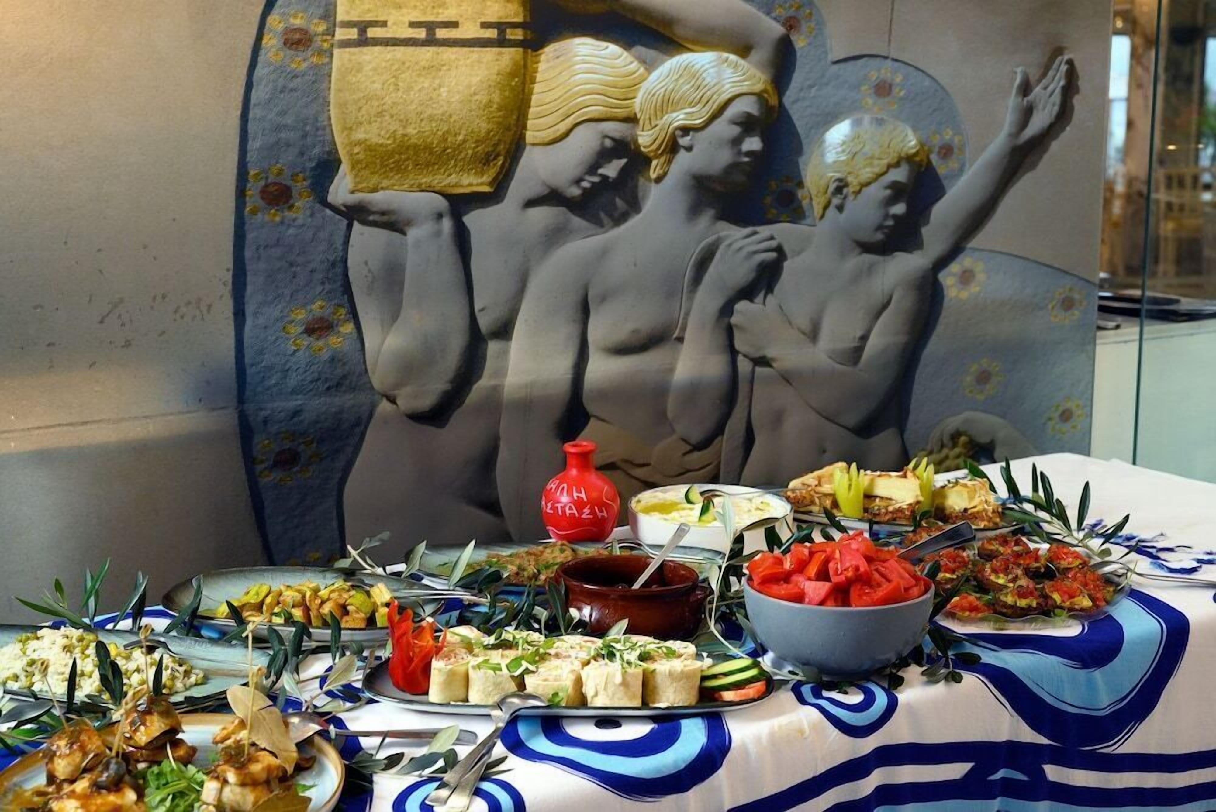 A table with various dishes and a decorative wall with a relief sculpture.