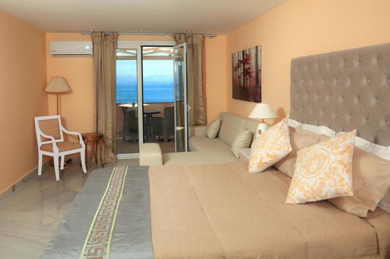 Una habitación de hotel con una cama, un sofá, una silla y un balcón con vistas.