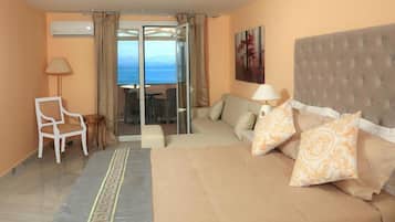 Una habitación de hotel con una cama, un sofá, una silla y un balcón con vistas.