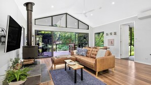 A modern living room with a large sofa, a coffee table, and a fireplace.