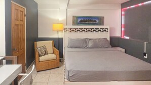 Ein Schlafzimmer mit Bett, Stuhl, Schreibtisch und Lampe.