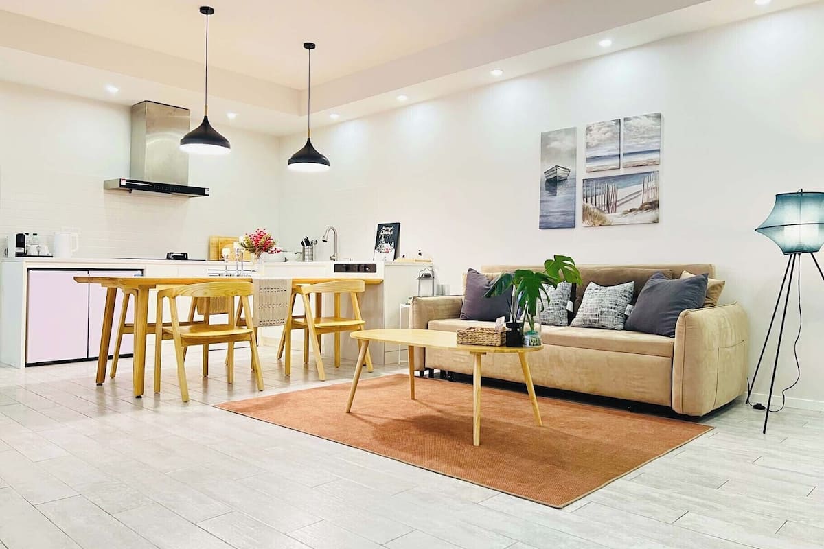 Uma sala de estar moderna com sofá, mesa de centro e área de jantar.