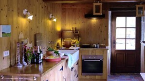 A wooden interior with a kitchen area, including a stove, sink, and various kitchen items. - Le Moulin Mathy - SAINT PIERRE LE VIEUX (SAINT PIERRE LE VIEUX)