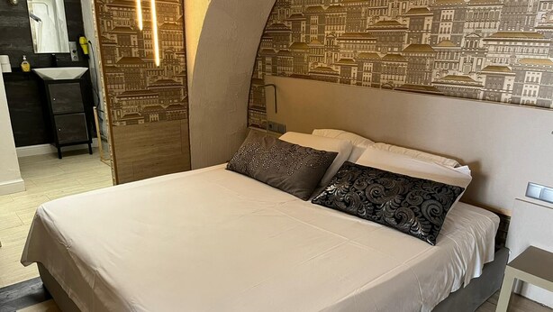 A bedroom with a large bed, two pillows, a nightstand, and a mirror. - ✨ Independent Stay: King Bed, Private Bathroom and Netflix (Faro)