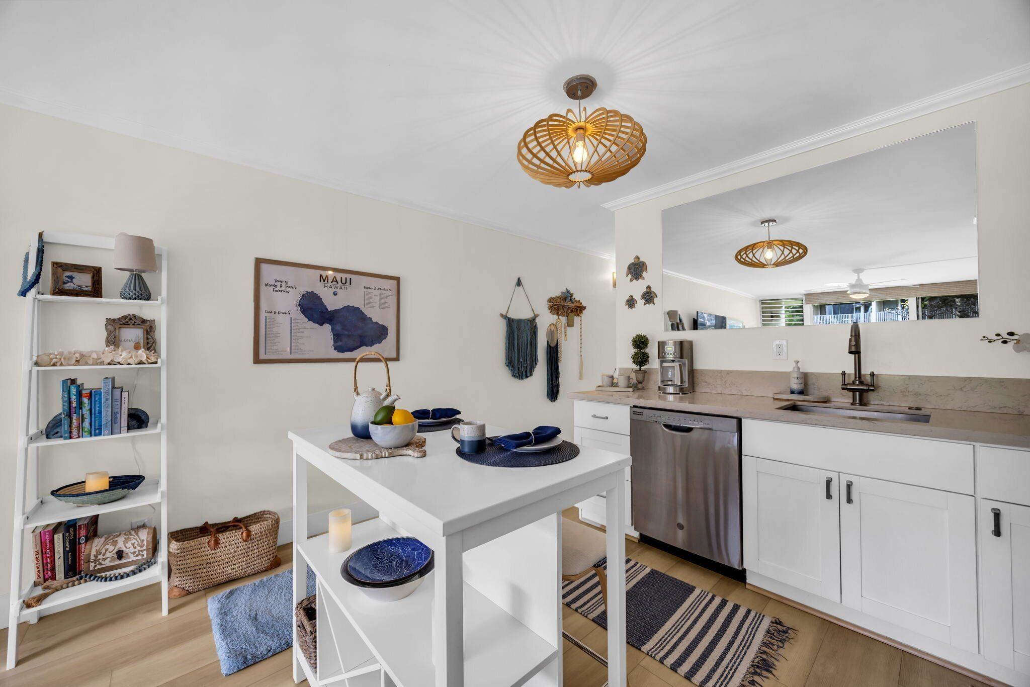 Une cuisine moderne avec des meubles blancs, une table à manger blanche et un luminaire suspendu.