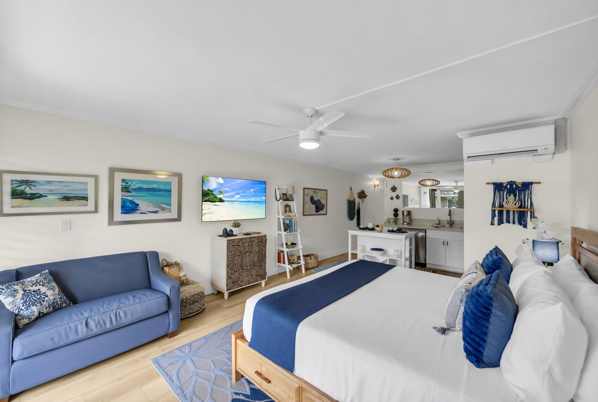 Une chambre d’hôtel moderne équipée d’un lit, d’un canapé, d’un bureau et d’une kitchenette.