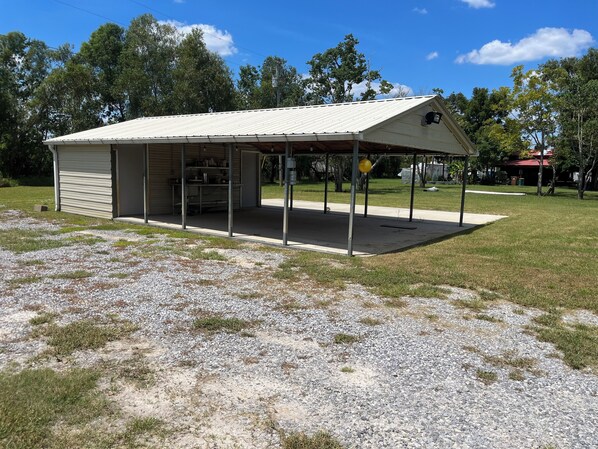 A single-story building with a covered patio area, a garage, and a small open space with a gravel floor.