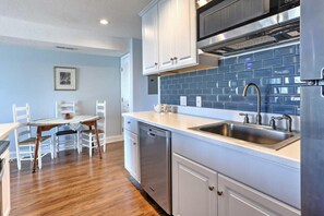A kitchen with white cabinets, a stainless steel sink, and a dishwasher. - Breakers B 17,1 bedroom, 1 bathroom newly remodeled, light and airy condo with pool (Carolina Beach)