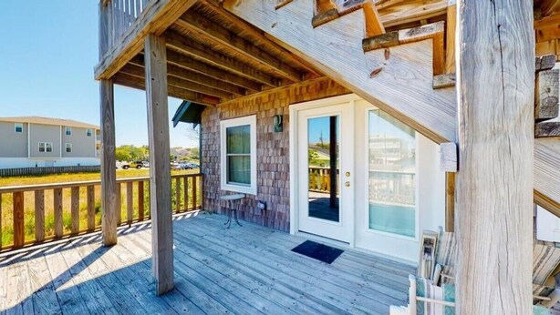 Una terrazza in legno con tettoia, una porta e una finestra.