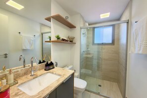 A modern bathroom with a large mirror, a sink, a toilet, and a glass-enclosed shower. - Apartment in Perdizes, 4th floor, with A/C, near Allianz Arena. (São Paulo)
