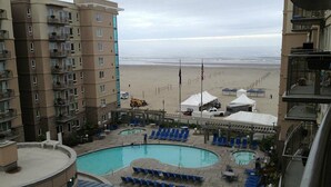 A hotel with a rooftop pool, lounge chairs, and a view of the beach. - 1-Bedroom Condo on the Ocean in Scenic Seaside with Fitness Room (Seaside)