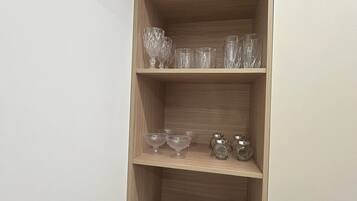 A corner shelf with various glassware and dishes.