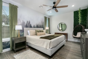 A bedroom with a bed, nightstands, a ceiling fan, a mirror, a dresser, and a green wall. - Ashwood Place | Sleeps 4, Pet Friendly w/ Fee, Hot Tub (Fredericksburg)