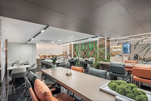 A modern dining area with tables and chairs, a reception desk, and a sign reading "Urban Ga". - Urban Garden Hotel Guangzhou Beijing Road Dashatou Wharf Branch (Guangzhou)