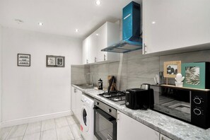 Fridge, microwave, oven, stovetop - Comfortable Four-Bedroom Stay with Balcony (London)