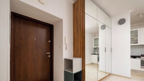 Eine moderne Küche mit weißen Schränken, einer Holztür und einer eingebauten Regaleinheit.