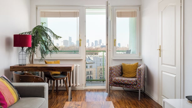 Un salon moderne comprenant un coin repas, un canapé, un fauteuil, une table et une plante en pot.