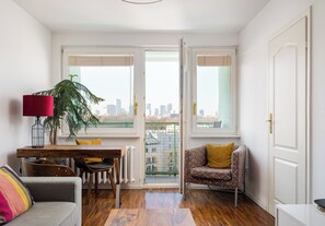Un salon moderne comprenant un coin repas, un canapé, un fauteuil, une table et une plante en pot.