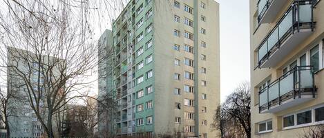 Un edificio residencial de varios pisos con balcones y una entrada portonada.
