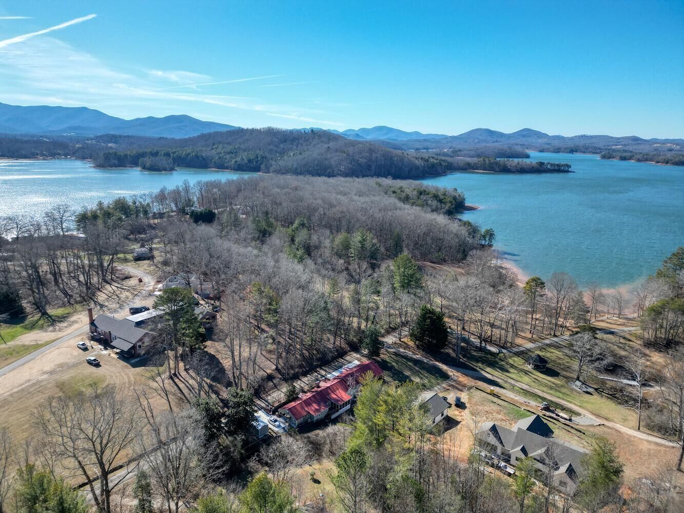Vista aérea de uma área residencial com casas, um cais e um lago.